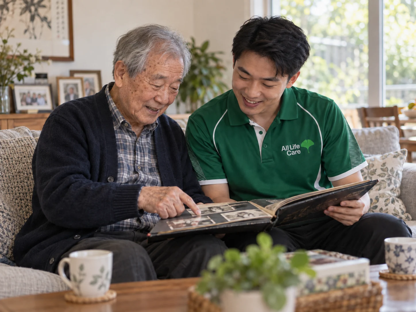 Older man and support worker looking through a family photo album together